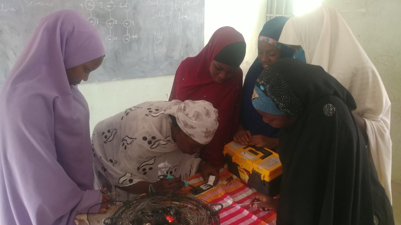 Community members gather to learn how to repair handsets. Photo courtesy of CITAD.