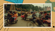 Banner photo showing bicycles, motorbikes and people moving through a busy intersection, many carrying packages, slightly blurred to show momentum. 